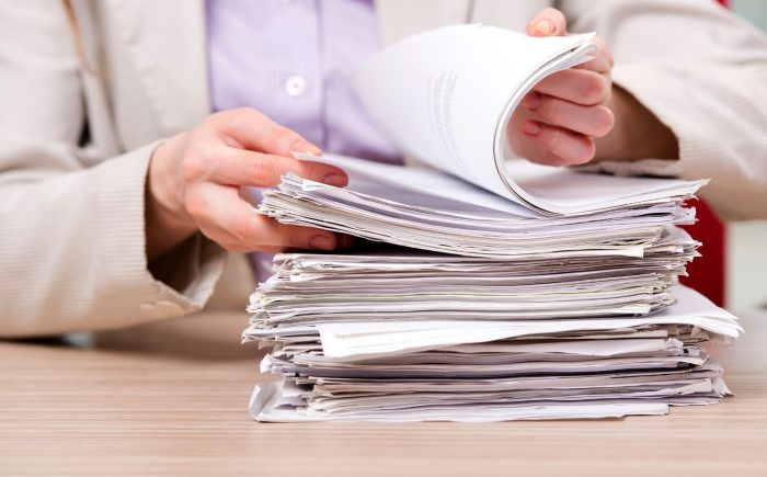 Person flipping through deed documents-min