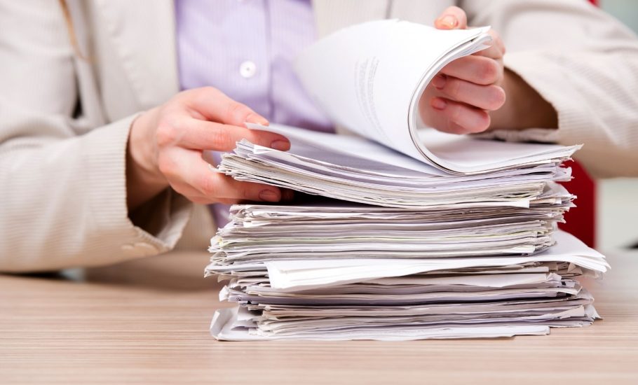 Person flipping through deed documents-min